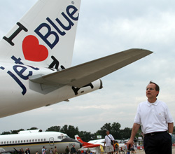 JetBlue CEO David Barger poses with the I Heart JetBlue Airbus A320 at Oshkosh 2011.