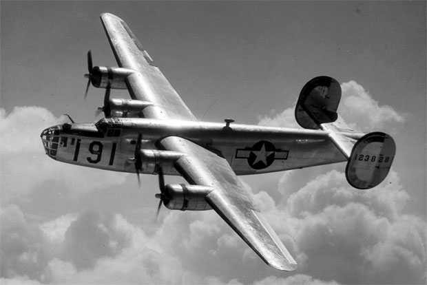 A Consolidated B-24 Liberator from Maxwell Field, Alabama, four engine pilot school, glistens in the sun as it makes a turn at high altitude in the clouds.